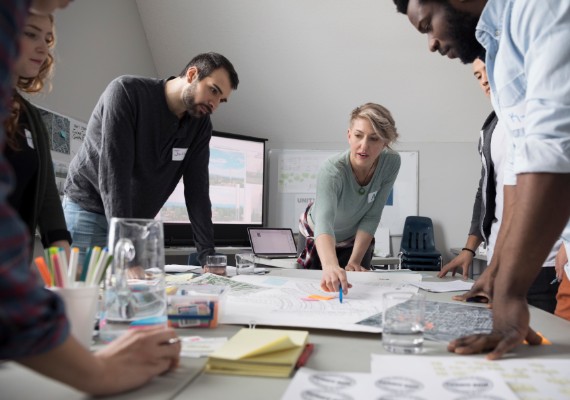Group of coworkers with drawings on the table